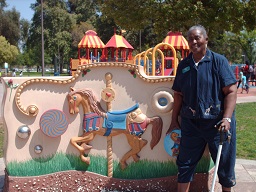Ms Lolita Barnard standing in front of the sensory park playground sign at Fairmount park
